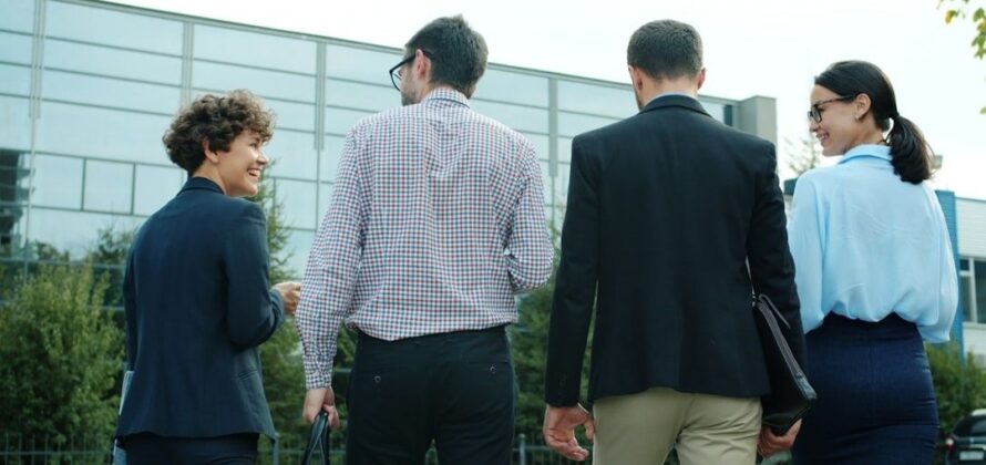 Vier collega’s lopen buiten samen tijdens een informeel overleg